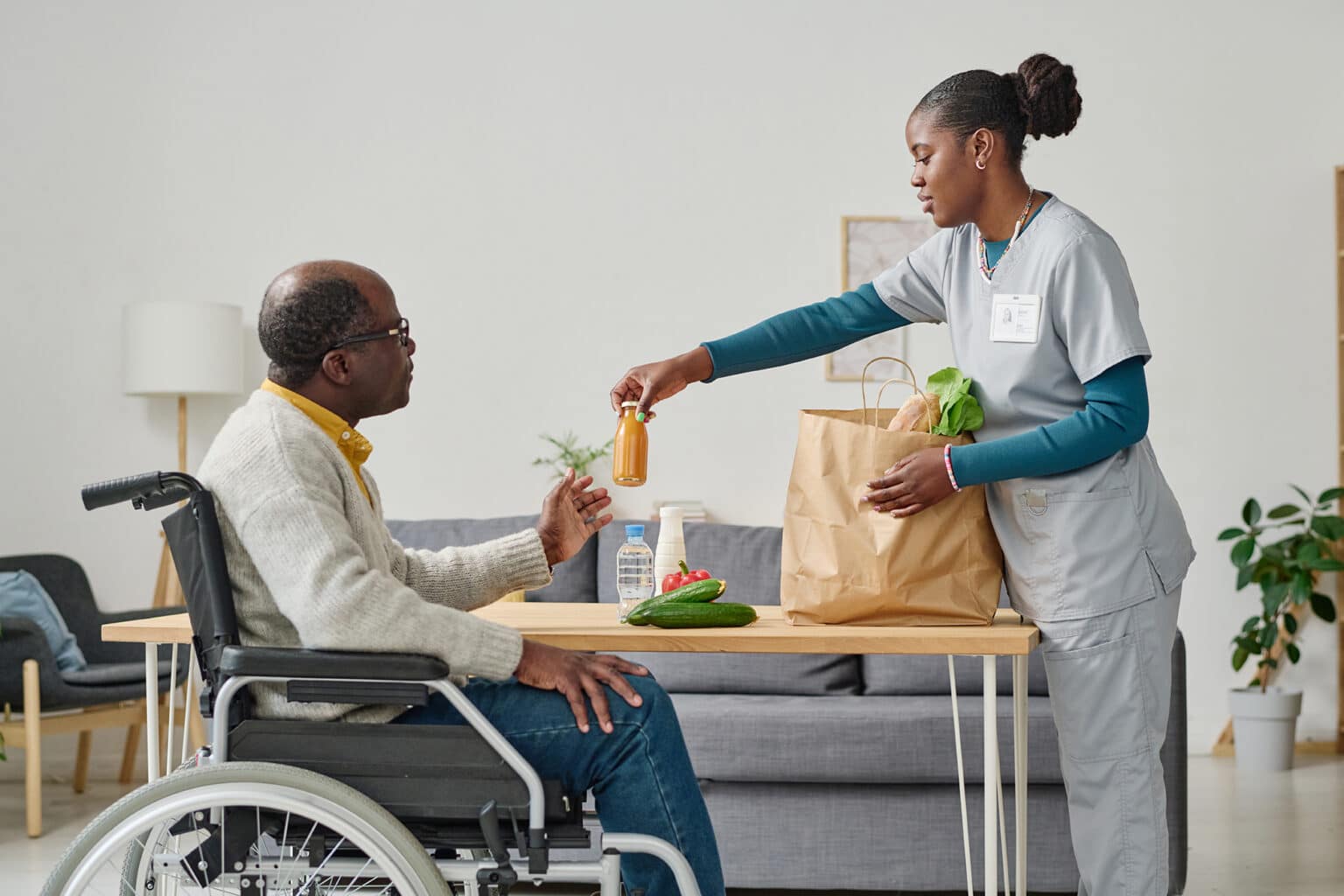 Nurse assisting resident with groceries.
