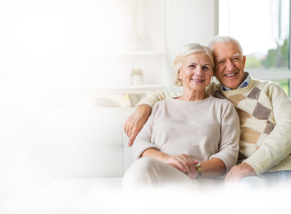 Happy senior couple sitting together indoors