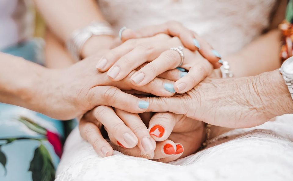 Hands of multiple individuals joined together.