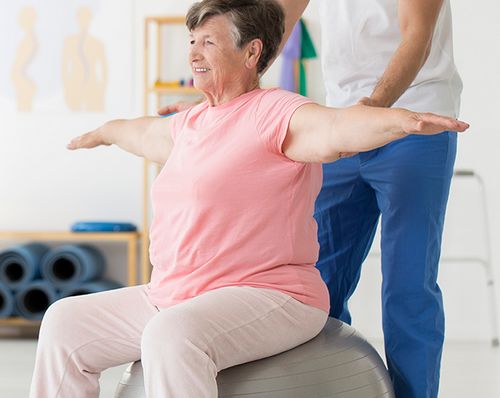 Senior woman exercising with assistance