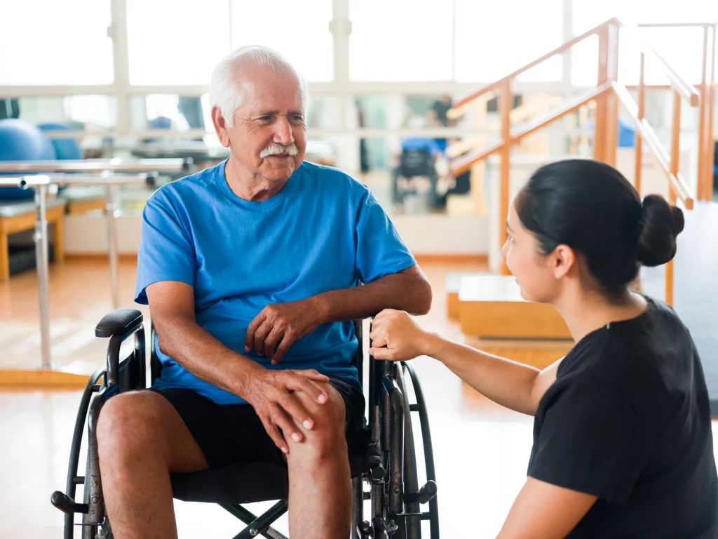Caregiver assisting a senior man in a wheelchair