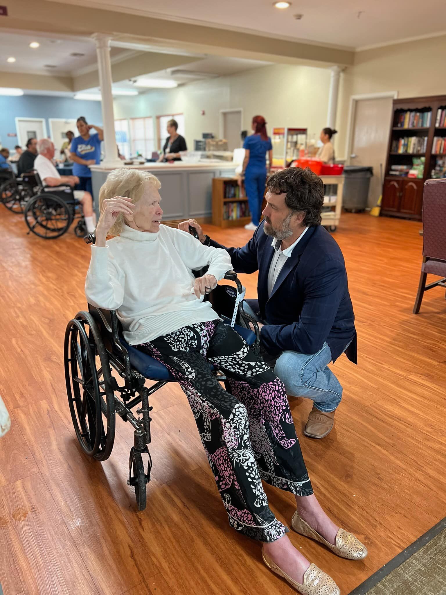 Staff member interacting with resident in wheelchair.