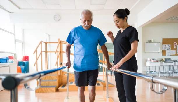 Physical therapy session with elderly man and staff member.
