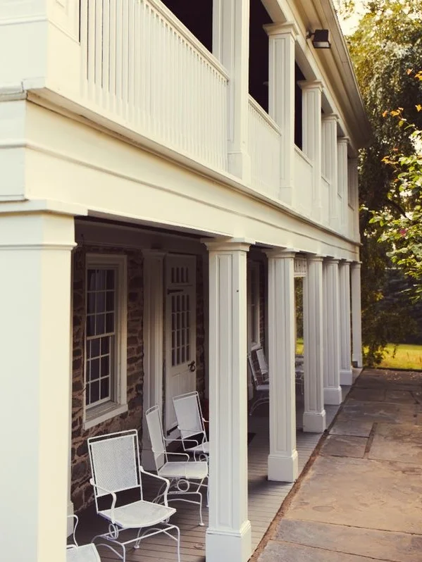 Exterior view of a building with rocking chairs