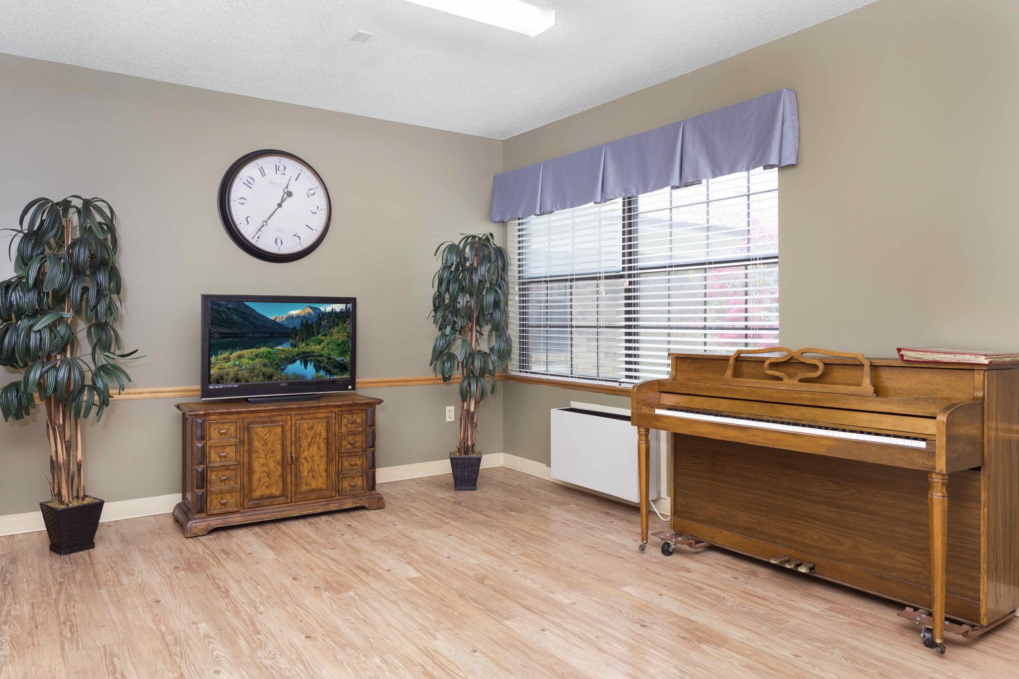 Bright common area with a piano and TV
