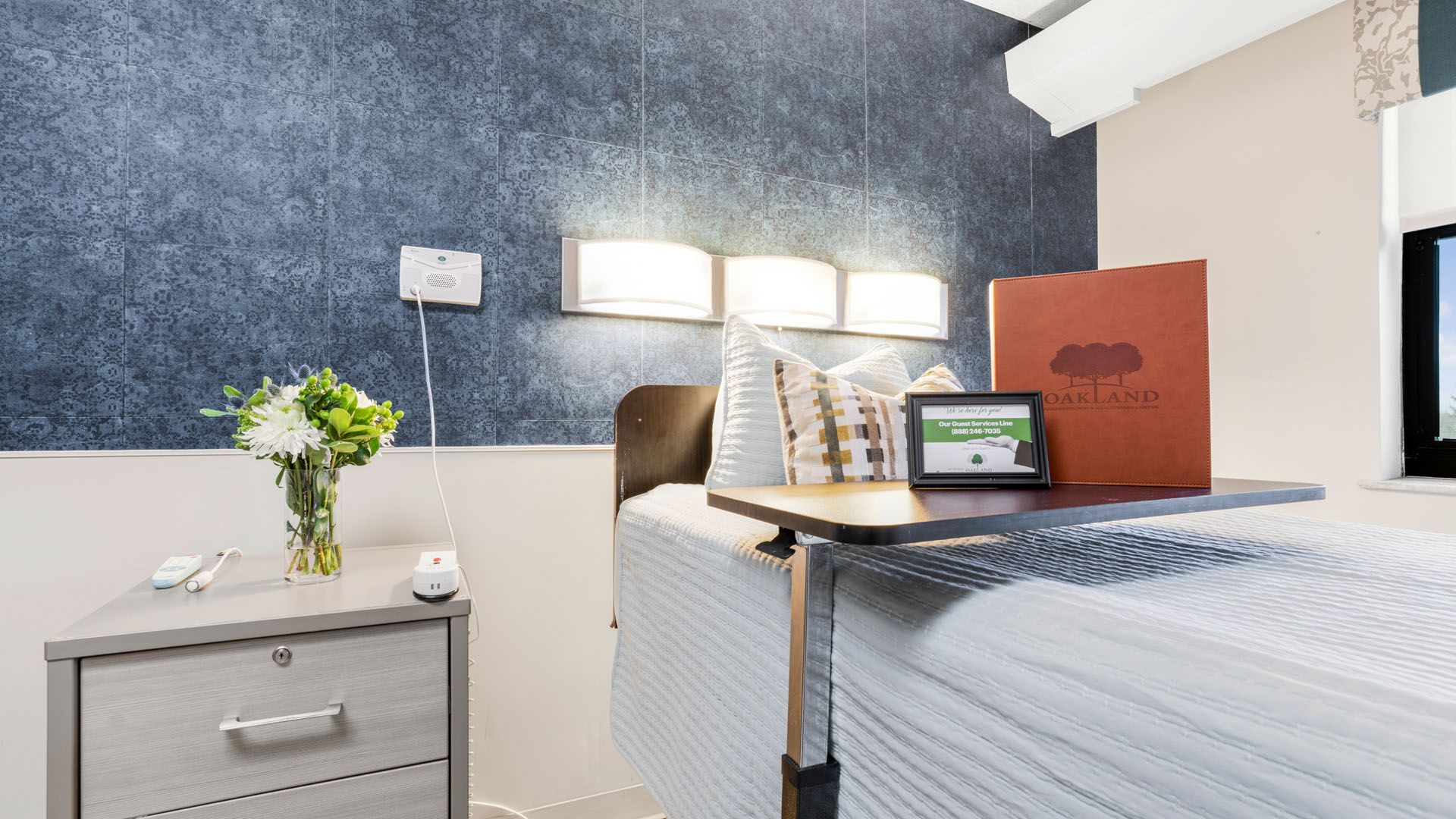 Cozy resident room with a bedside table and flowers