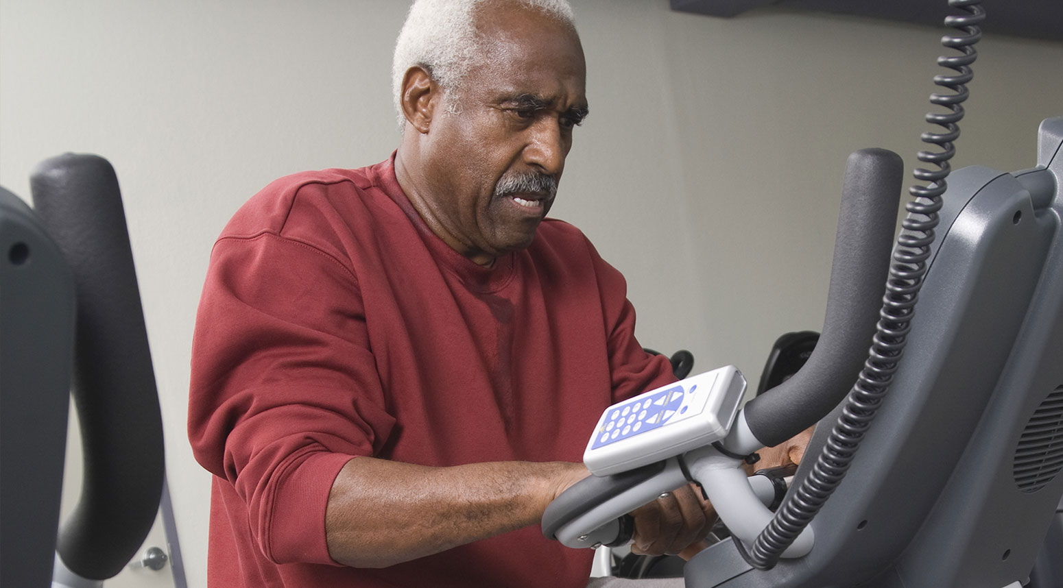 A senior resident exercising on an elliptical machine