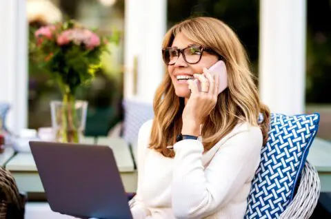 Woman talking on a phone in a garden setting