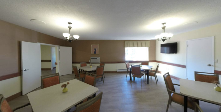 Common area with tables and chairs in a well-lit room