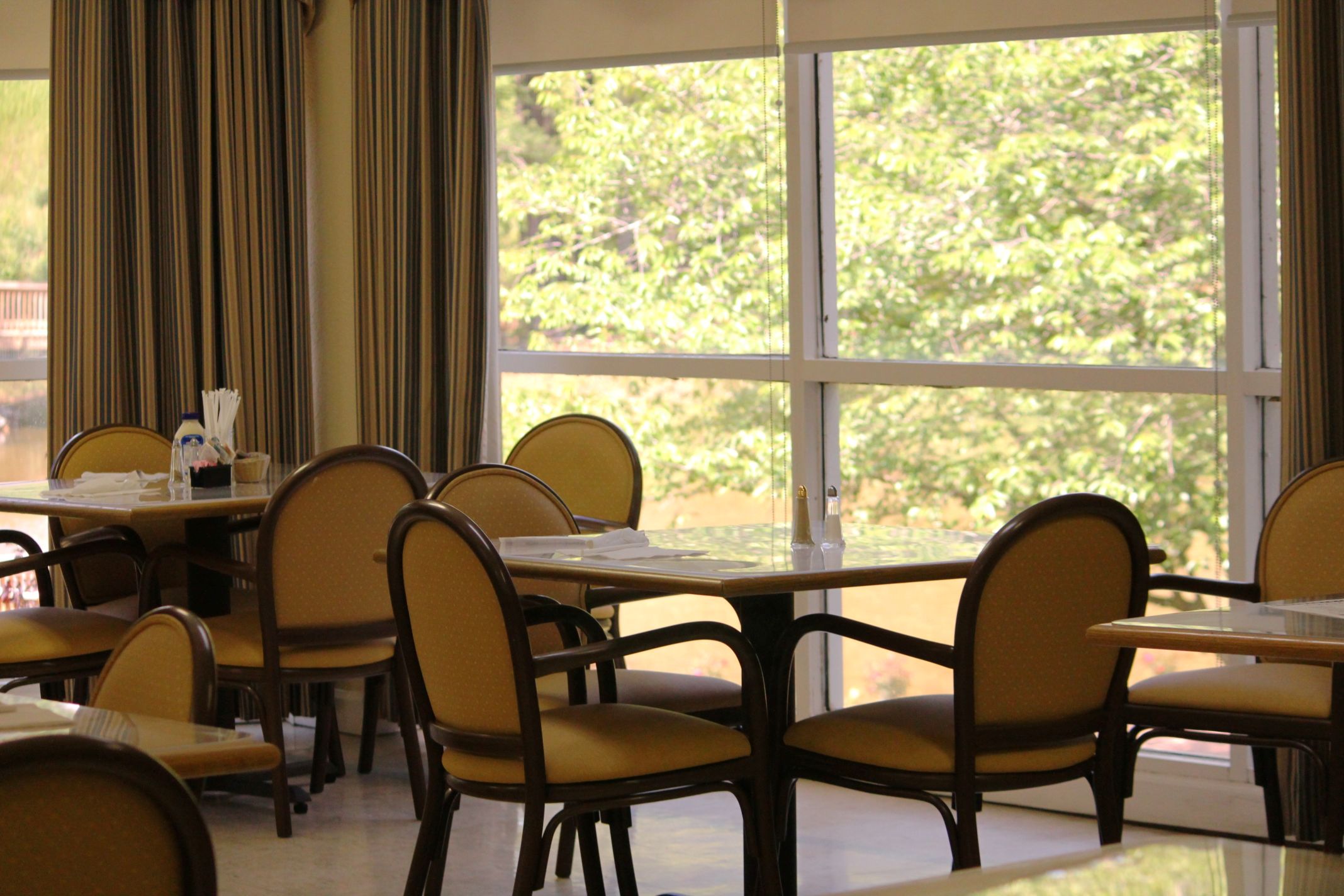 Dining area with tables and chairs, large windows