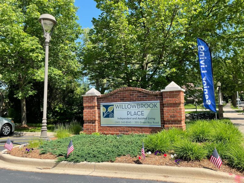 Exterior sign of Willowbrook Place with landscaping