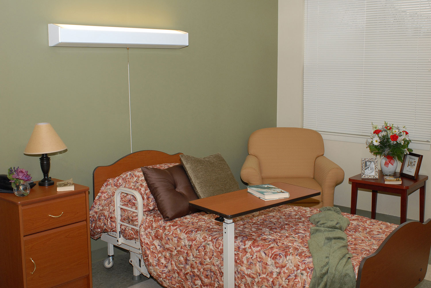 Cozy private room with a hospital bed and seating area