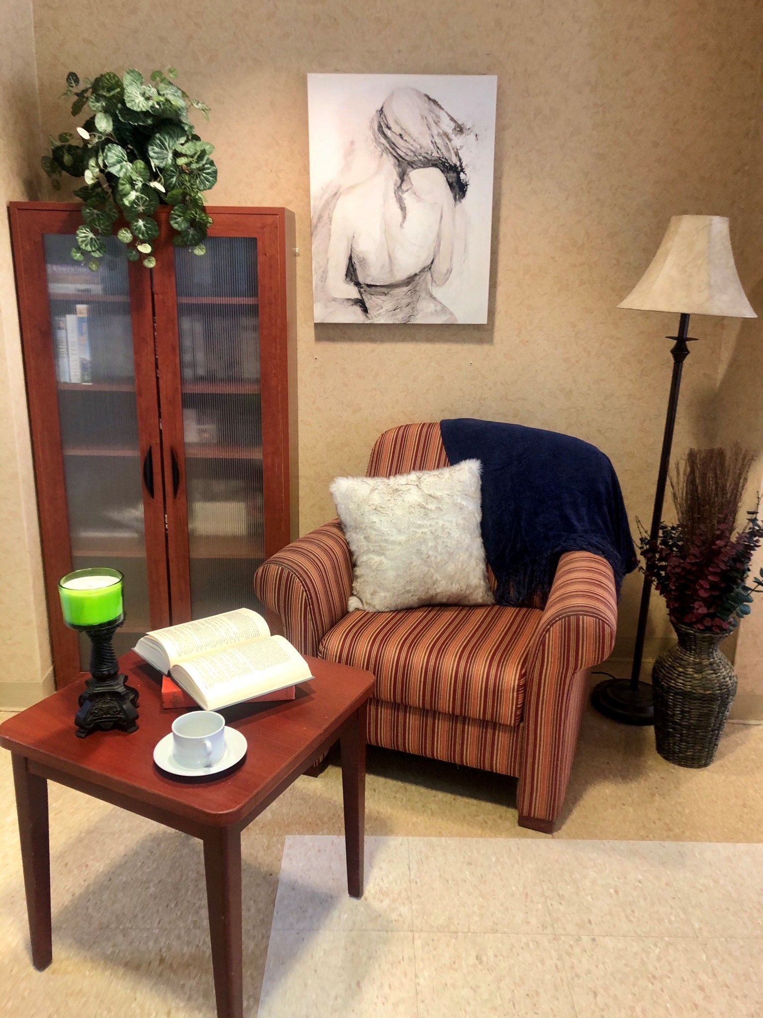 Cozy reading corner with chair, lamp, and decor.