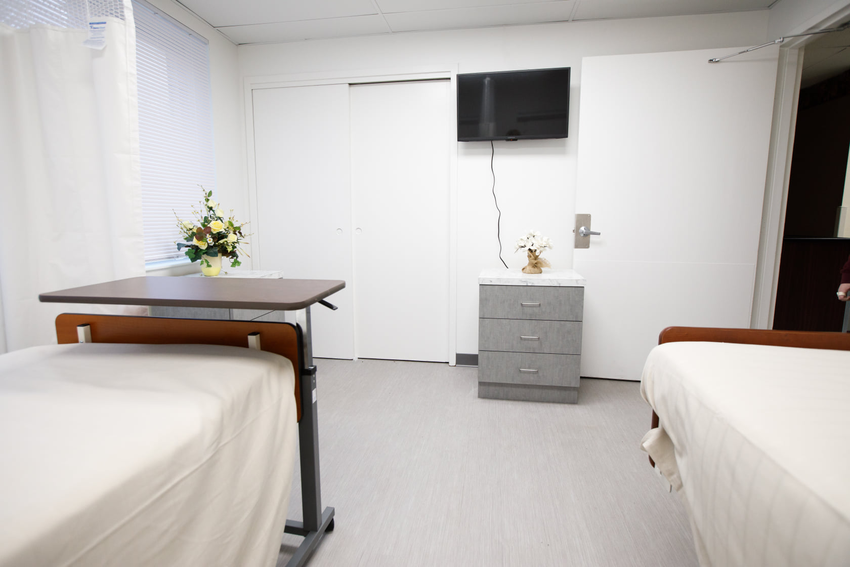 Private resident room with two beds and a TV