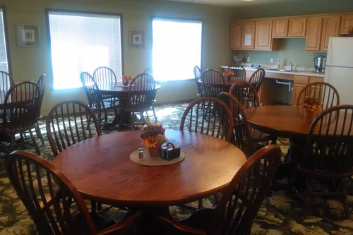 Dining area with wooden tables and chairs in a warm setting
