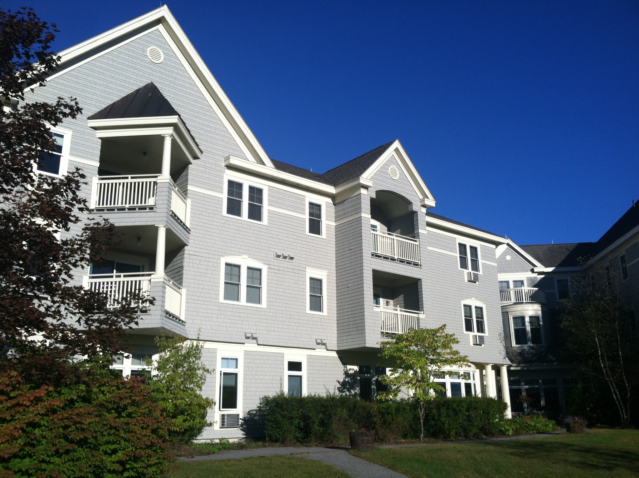 Exterior view of a senior living facility with gardens