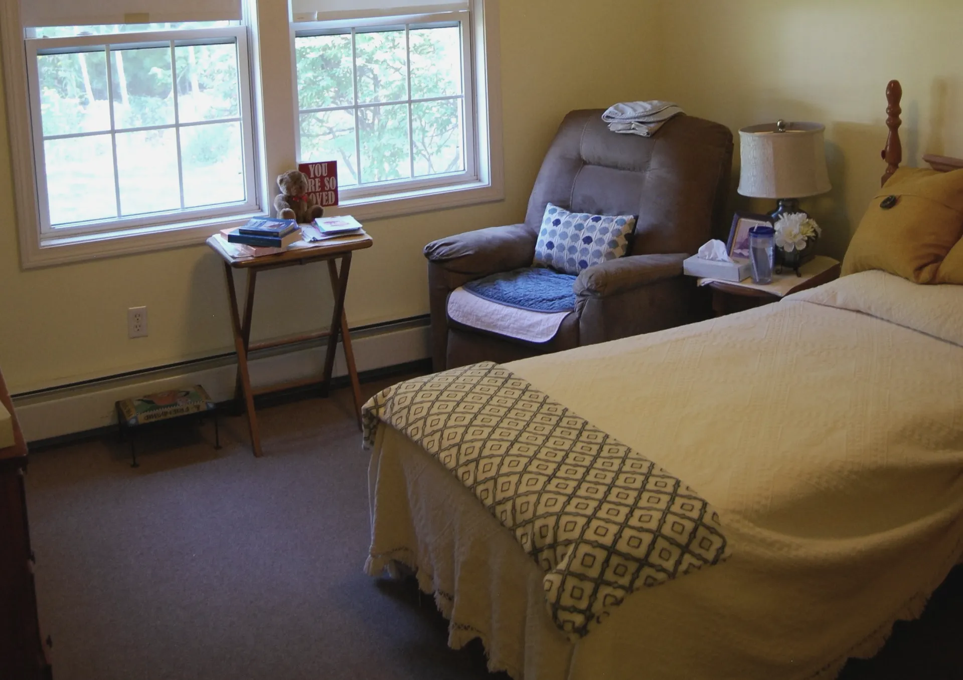 Cozy private resident room with a chair and bedside table