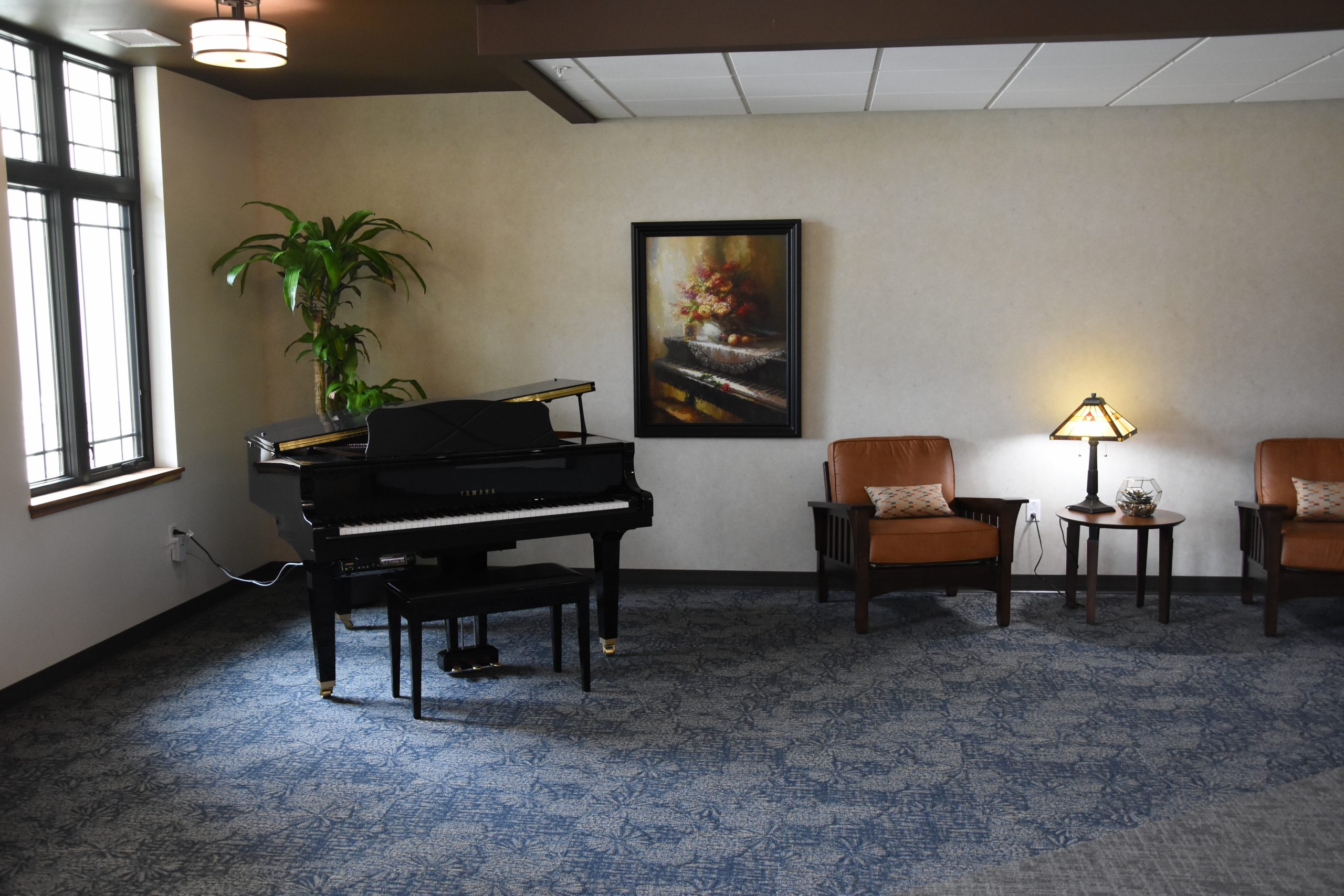 Interior view of a common area with a piano and seating