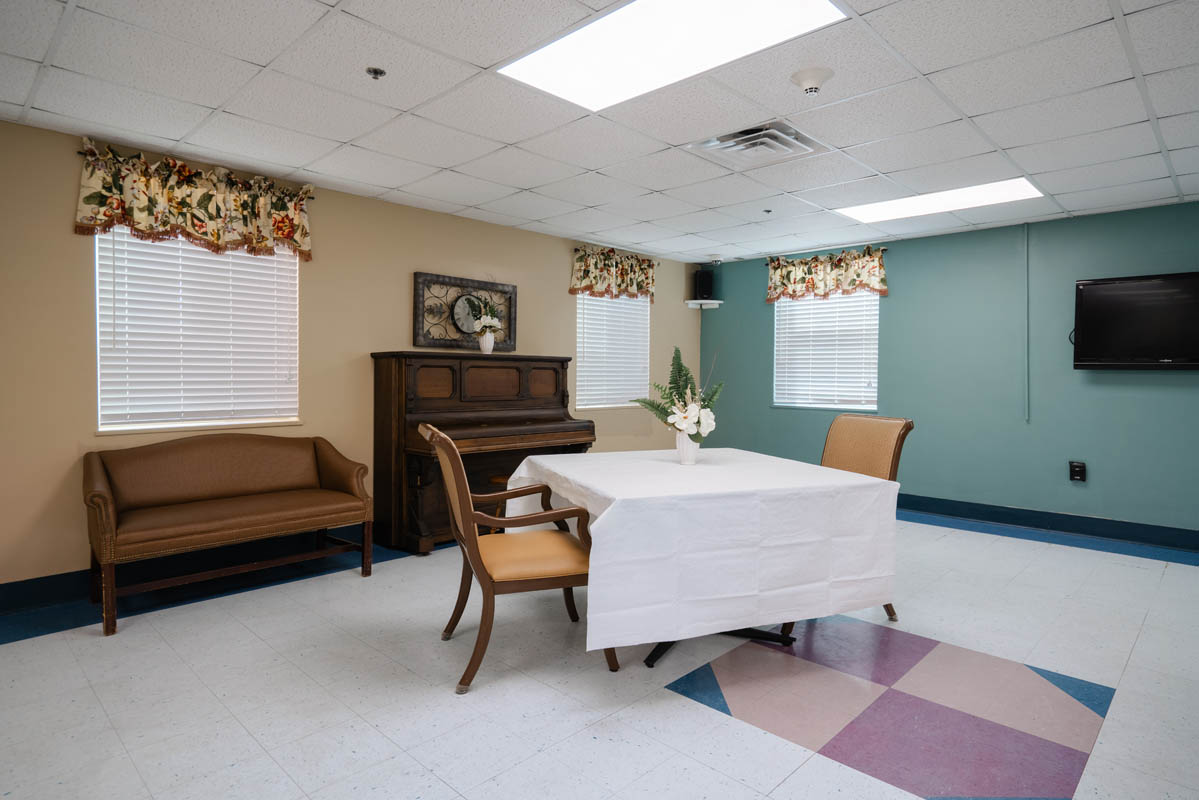 Bright common area with a piano and dining table
