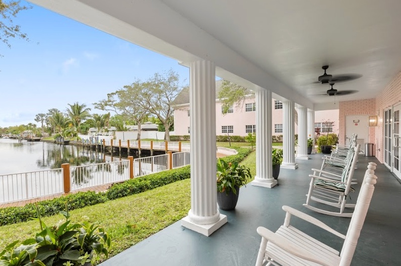 Covered porch area with rocking chairs overlooking water