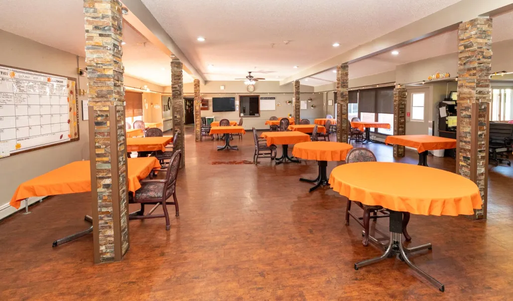 Dining area with orange tablecloths and chairs