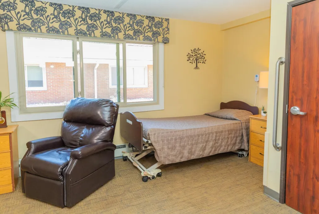 Private resident room with a bed and reclining chair