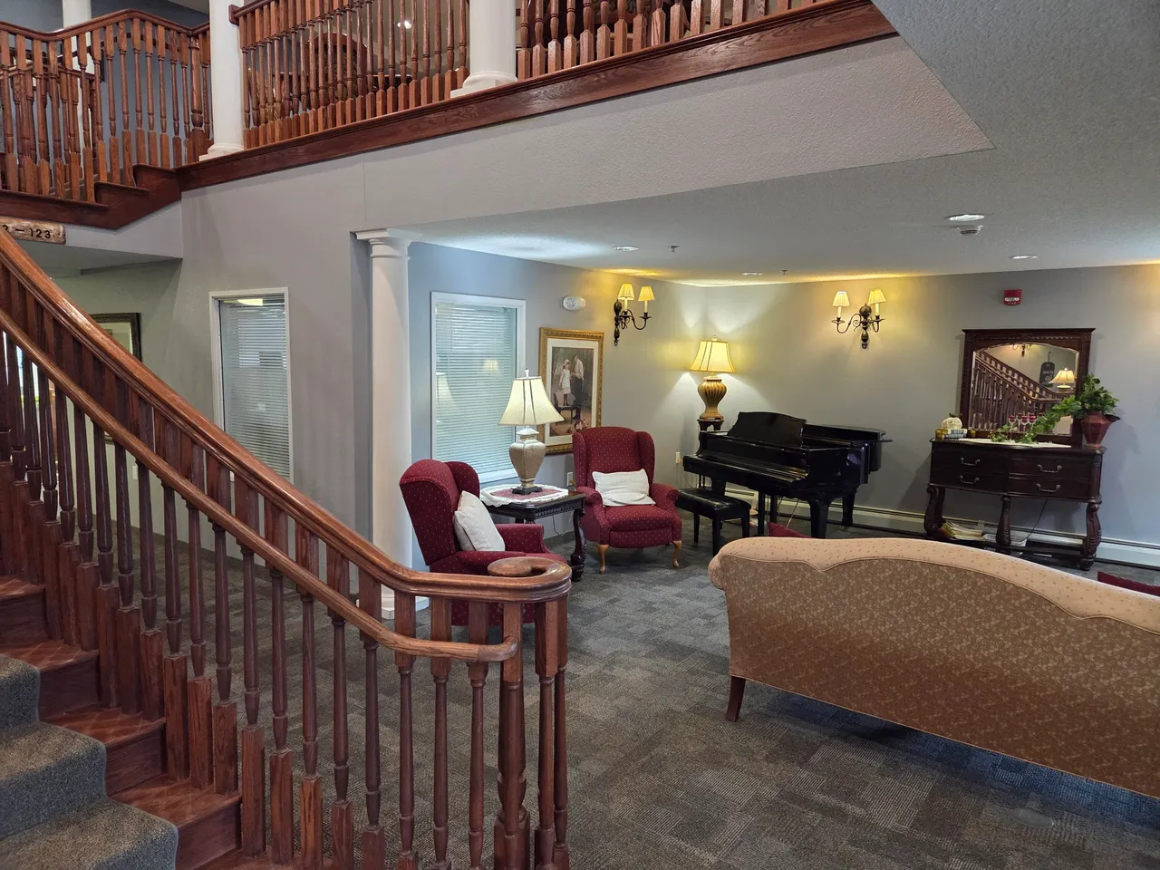 Interior view of a cozy common area with seating and piano