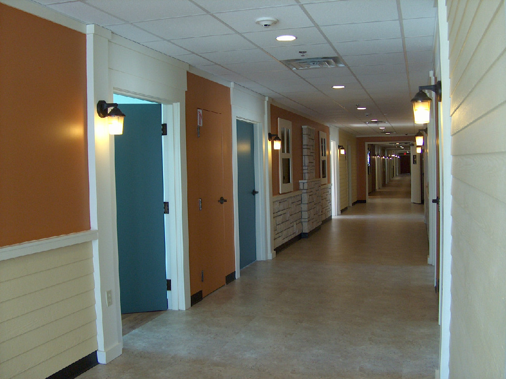 Hallway with orange and blue doors in a facility