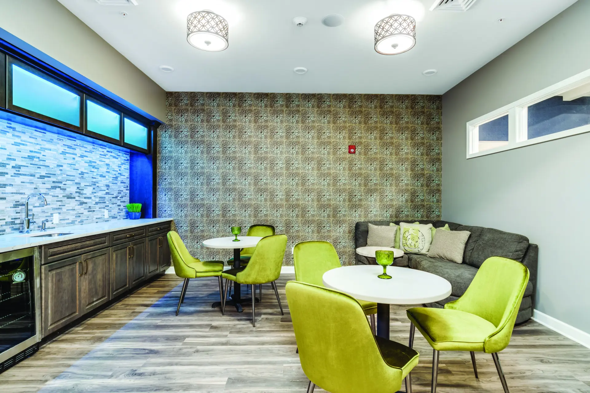 Bright common area with green chairs and tables