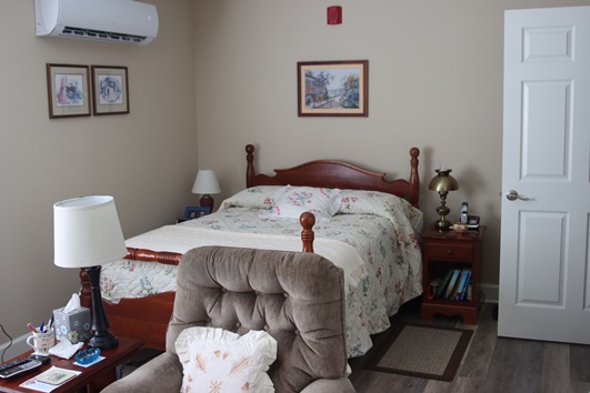 Cozy resident room with a bed and armchair