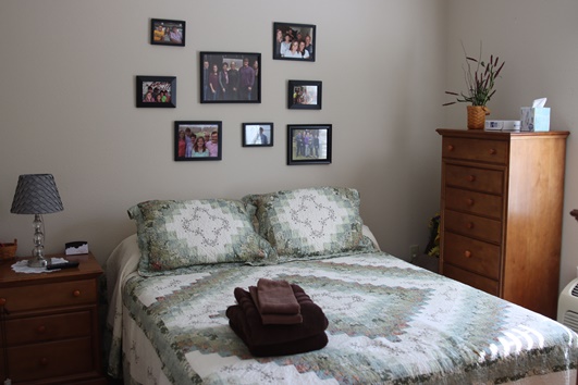 A cozy bedroom setup with personal photos on the wall