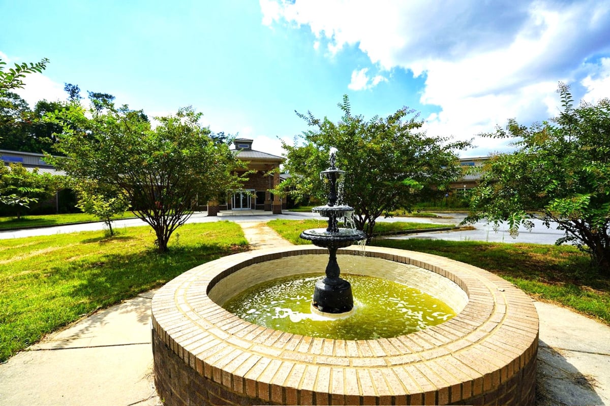 Outdoor fountain surrounded by greenery at the facility