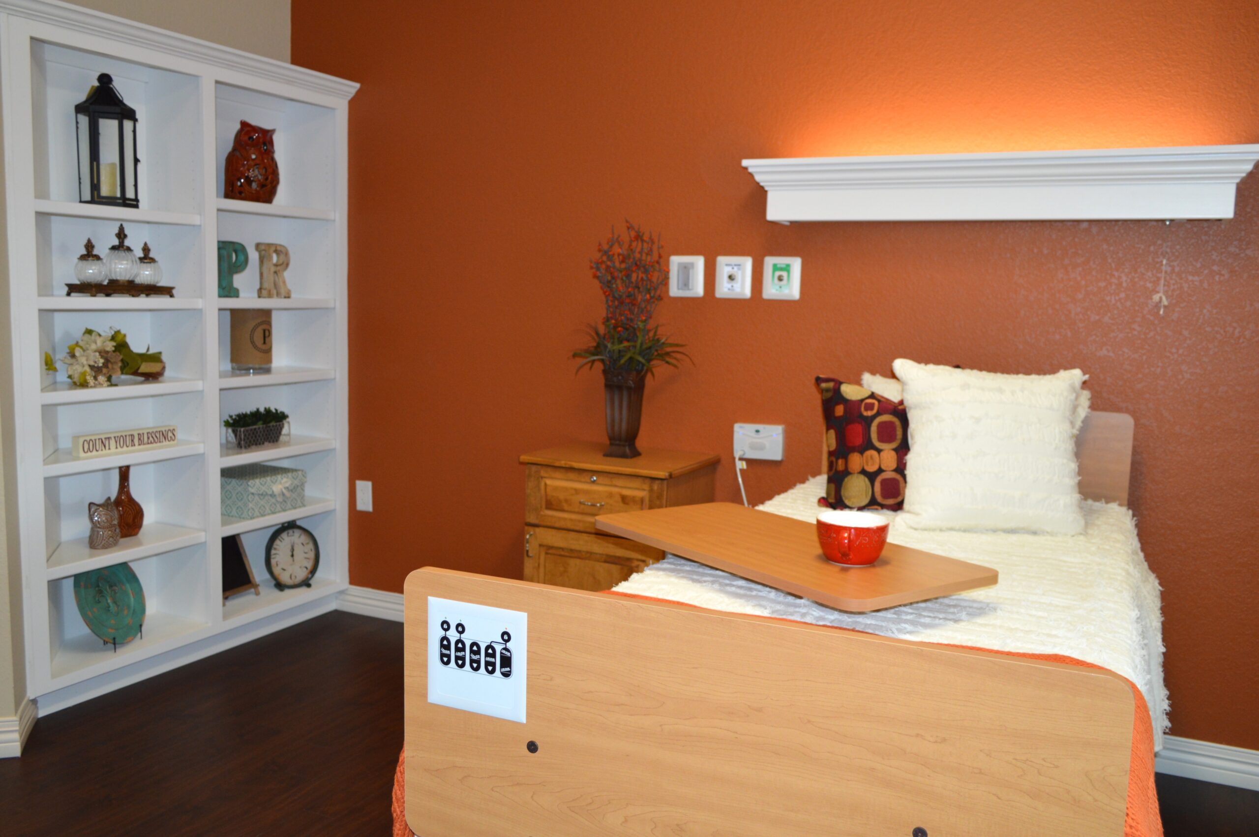 Cozy resident room with a decorative shelf and bed