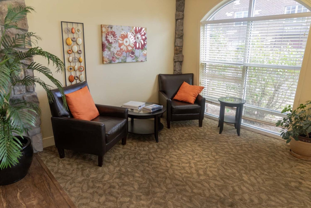 Well-lit common area with armchairs and decor
