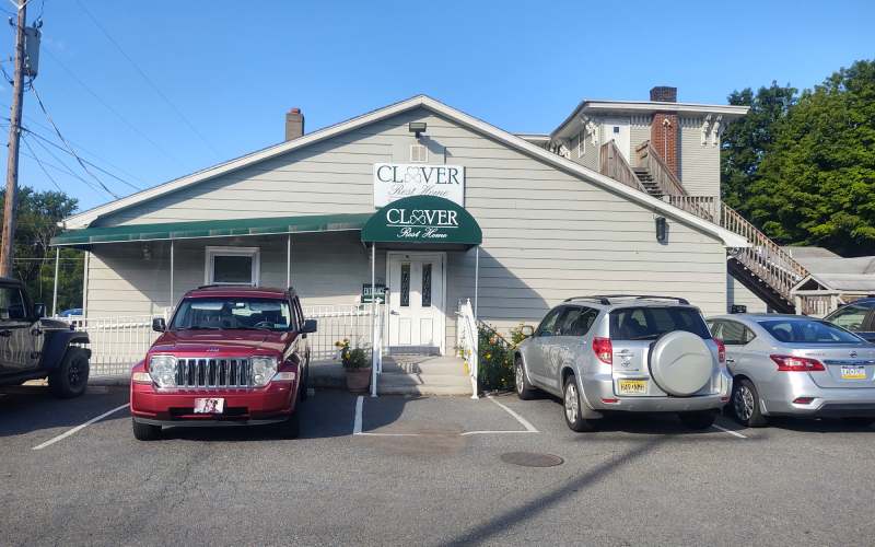 Exterior view of Clover Rest Home with signage