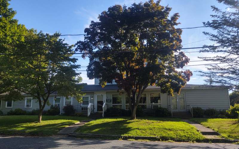 Exterior view of Clover Rest Home with trees
