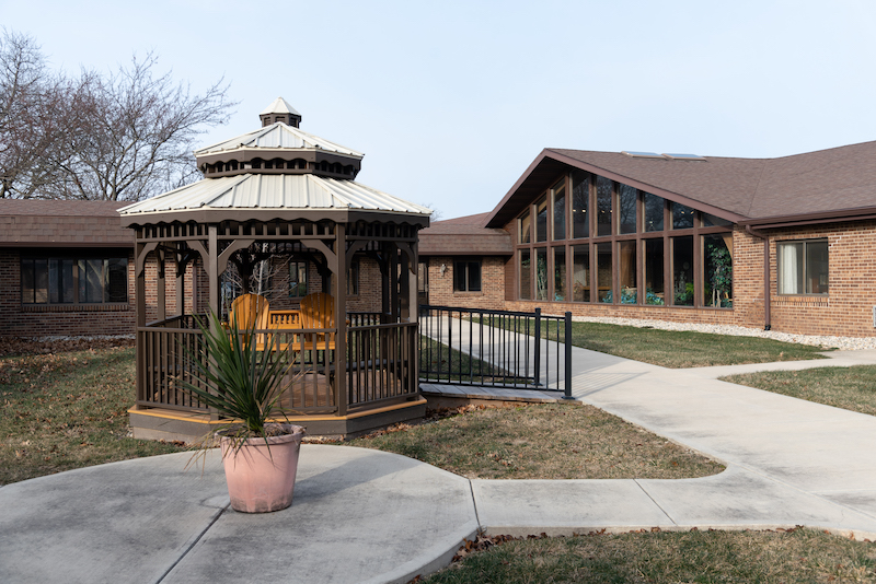 Outdoor gazebo with seating near the facility entrance