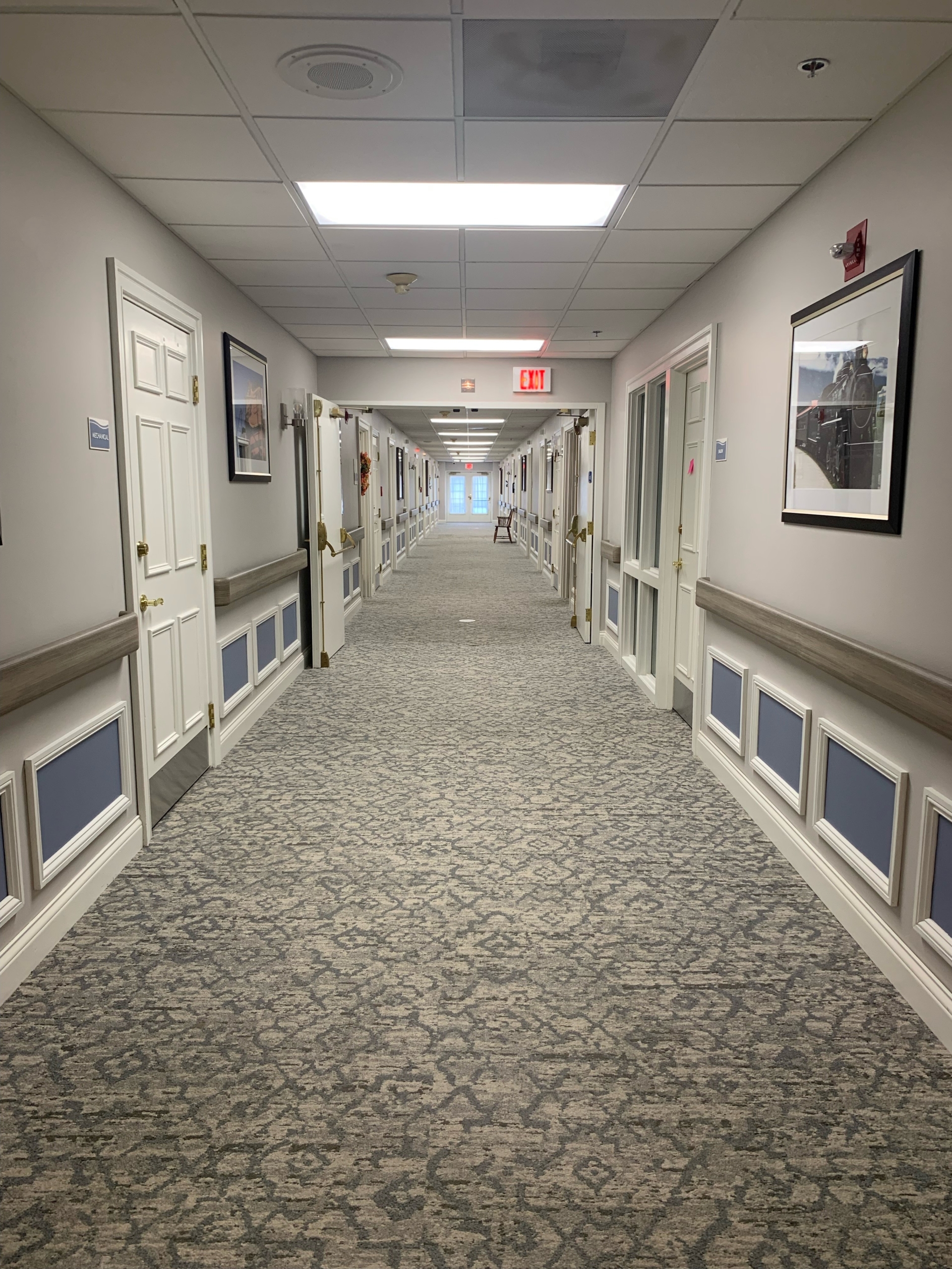 Bright corridor with framed pictures and carpeted floors
