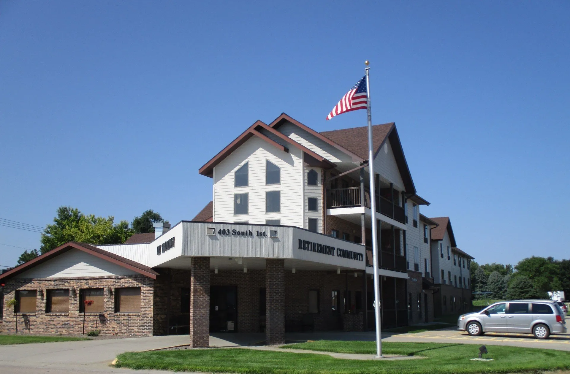 Exterior view of Off Broadway Apartments with flag