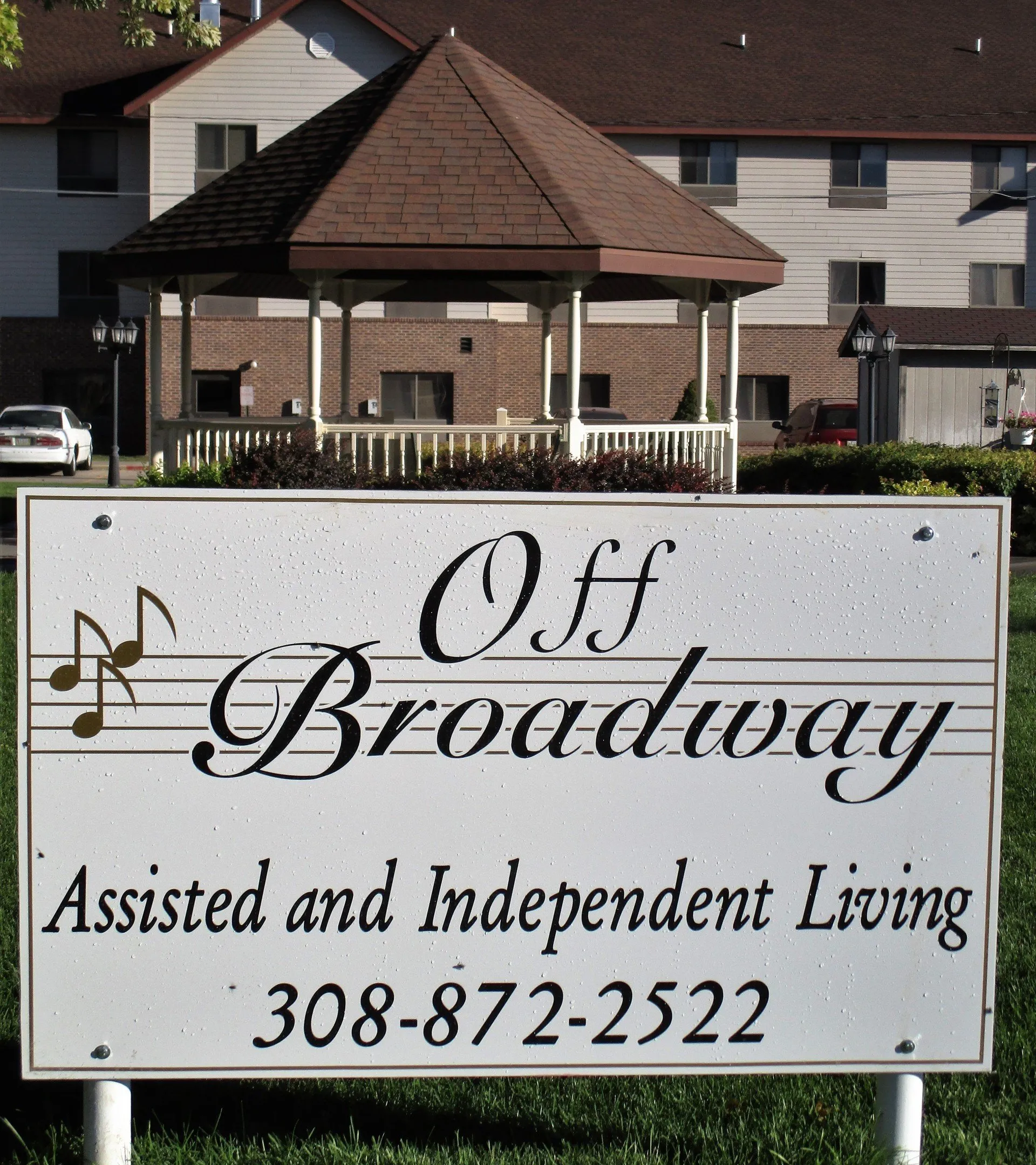 Sign for Off Broadway Apartments in front of a building