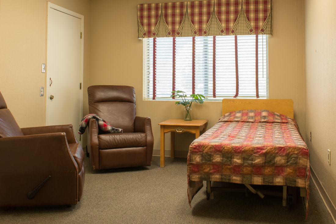 Private resident room with bed and chairs