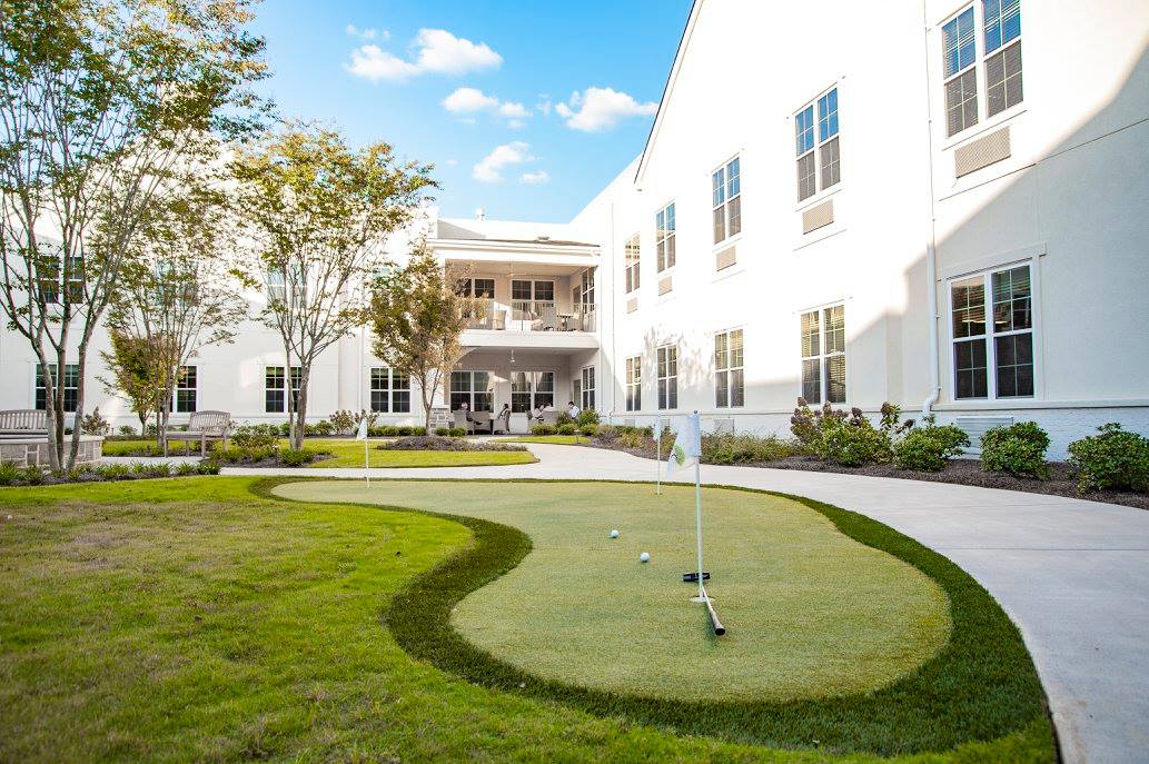 Outdoor putting green with lawn space and building