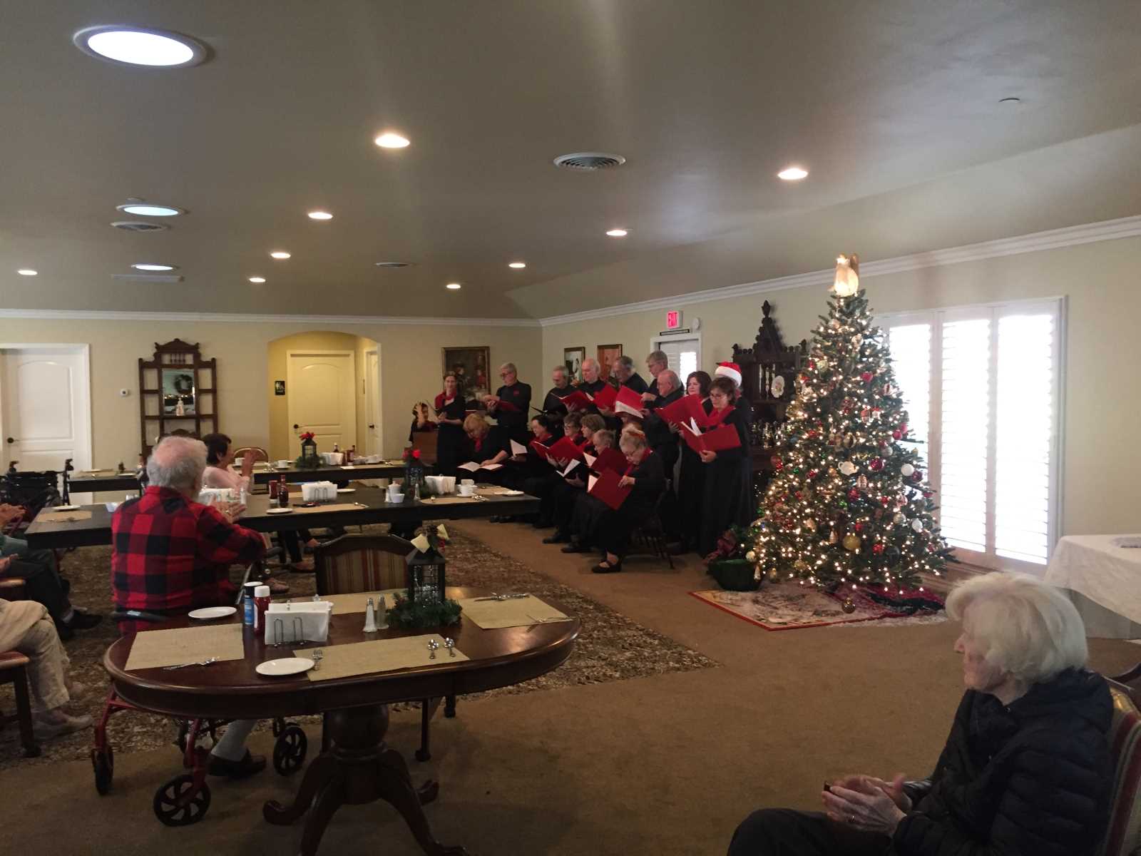 Residents enjoy a holiday choir performance indoors.