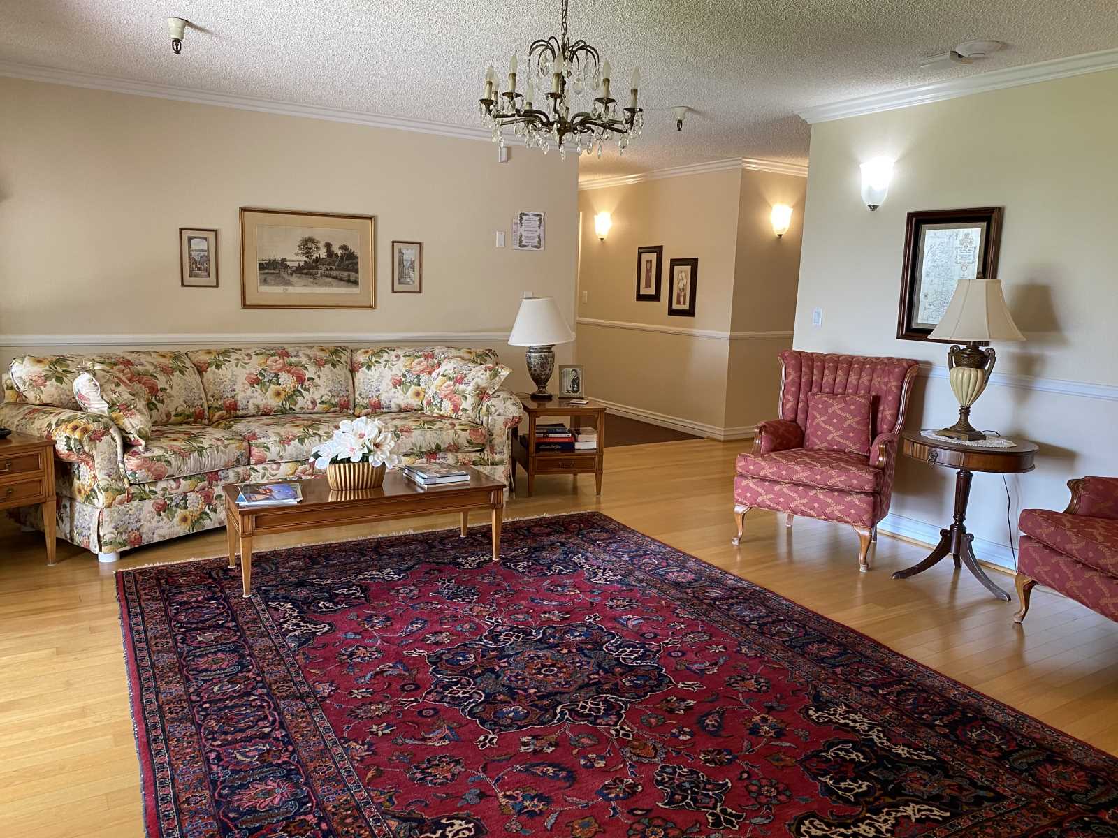 Comfortable common area with floral furniture and rug.