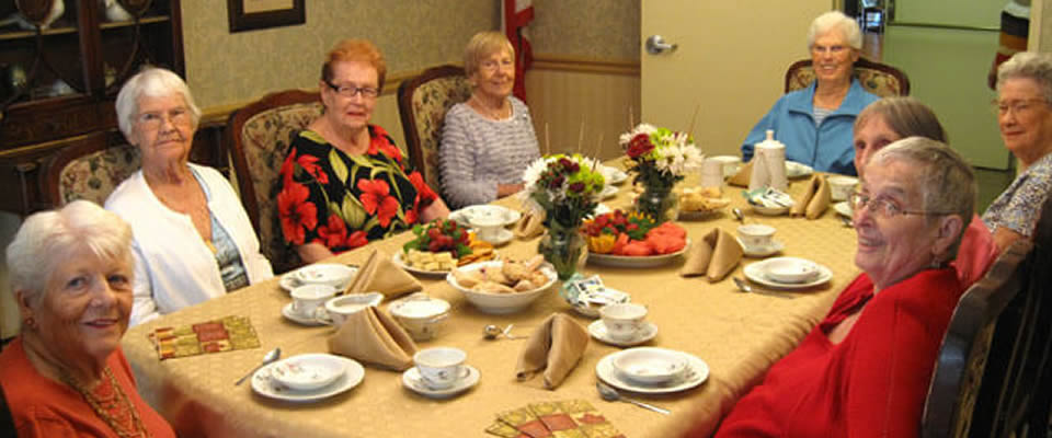 Seniors enjoying a meal together in a dining room.
