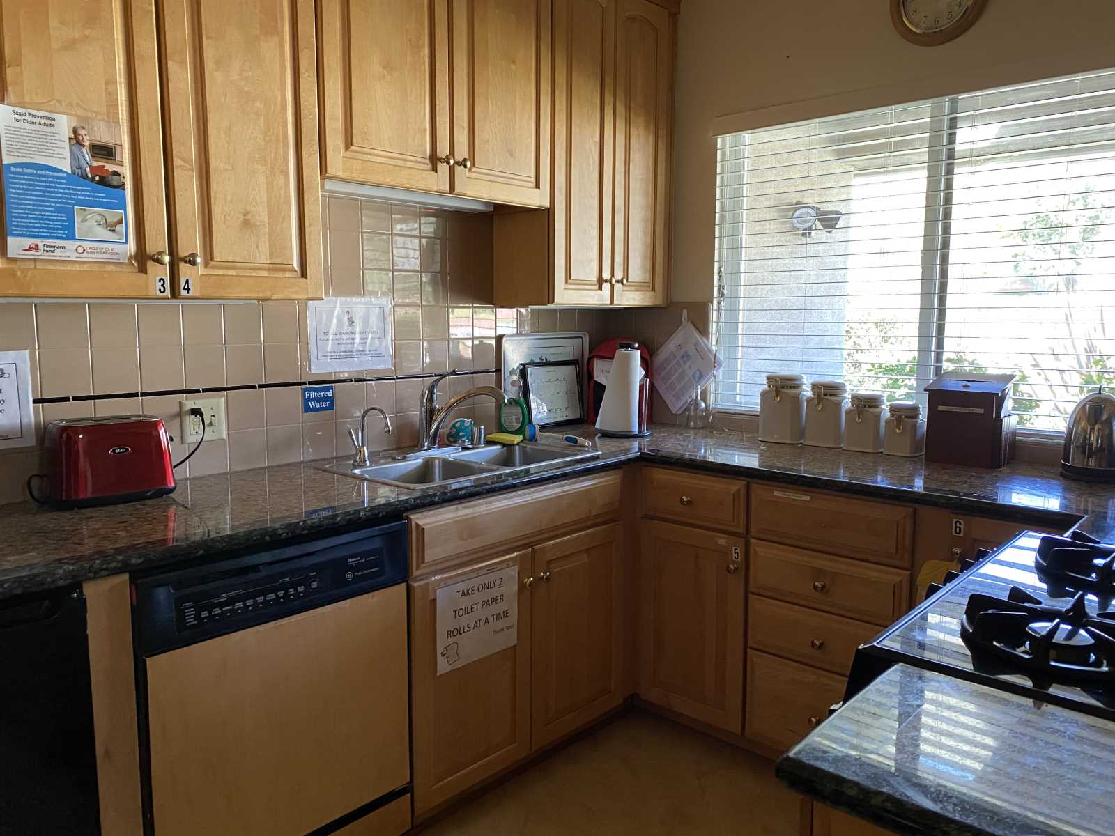 Bright kitchen area with wooden cabinets and countertop.