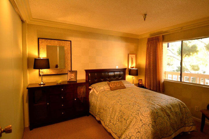 Cozy bedroom with a bed, dresser, and window.