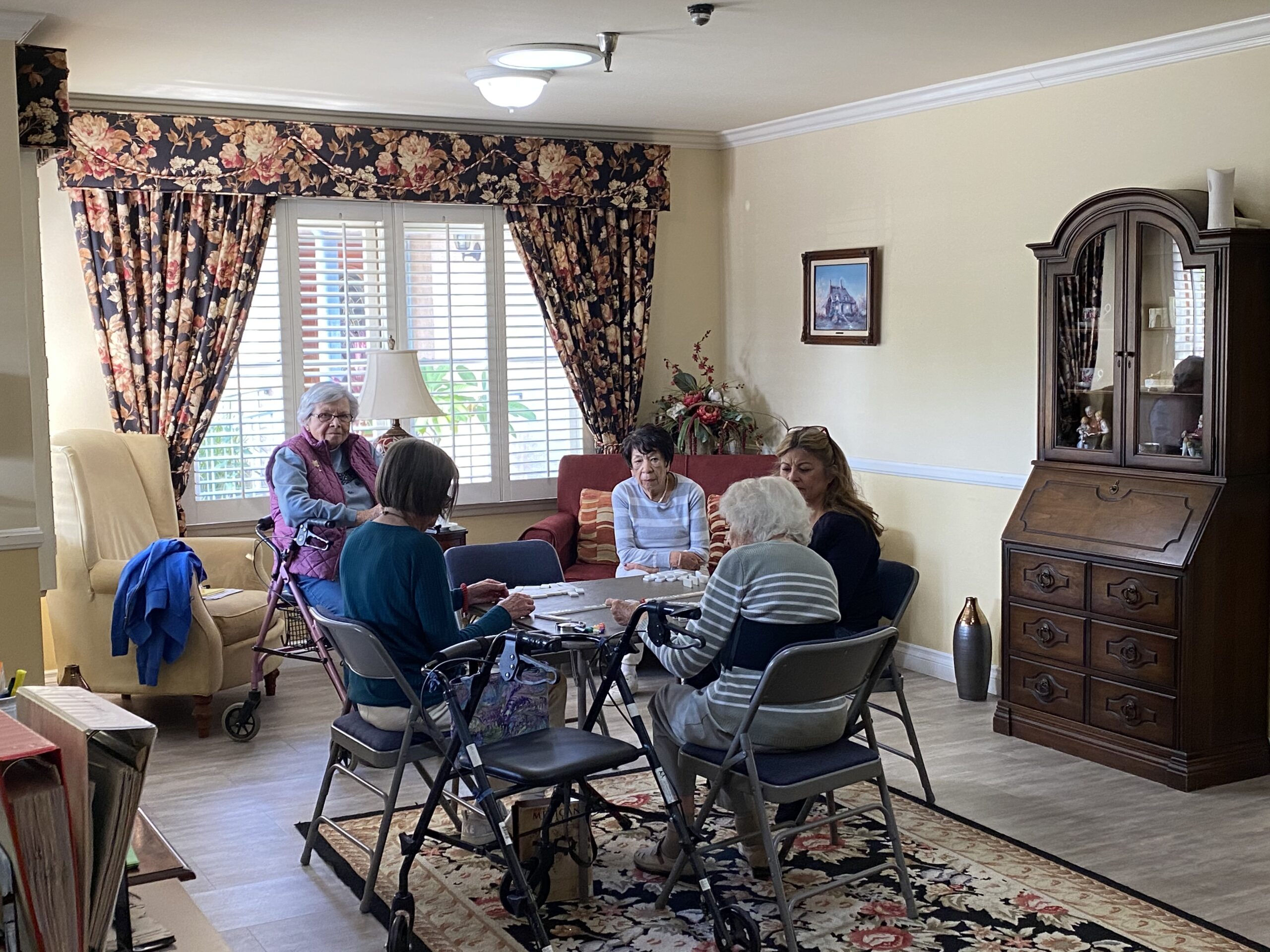 Residents engaging in a card game in the common area.