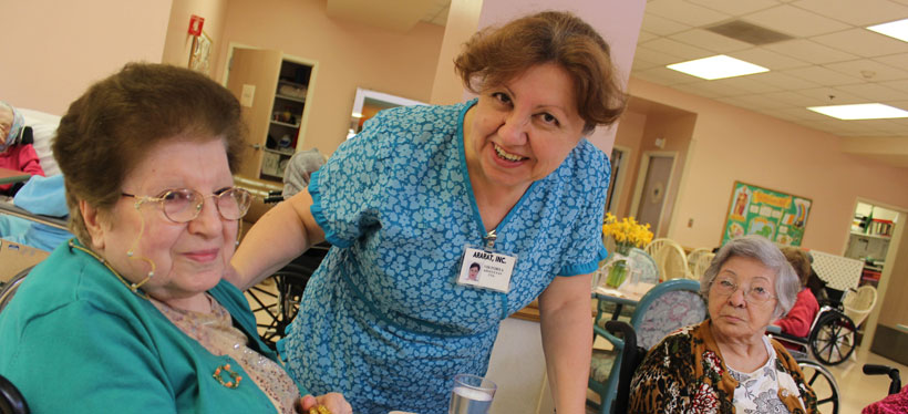 Caregiver interacting with residents in a common area.