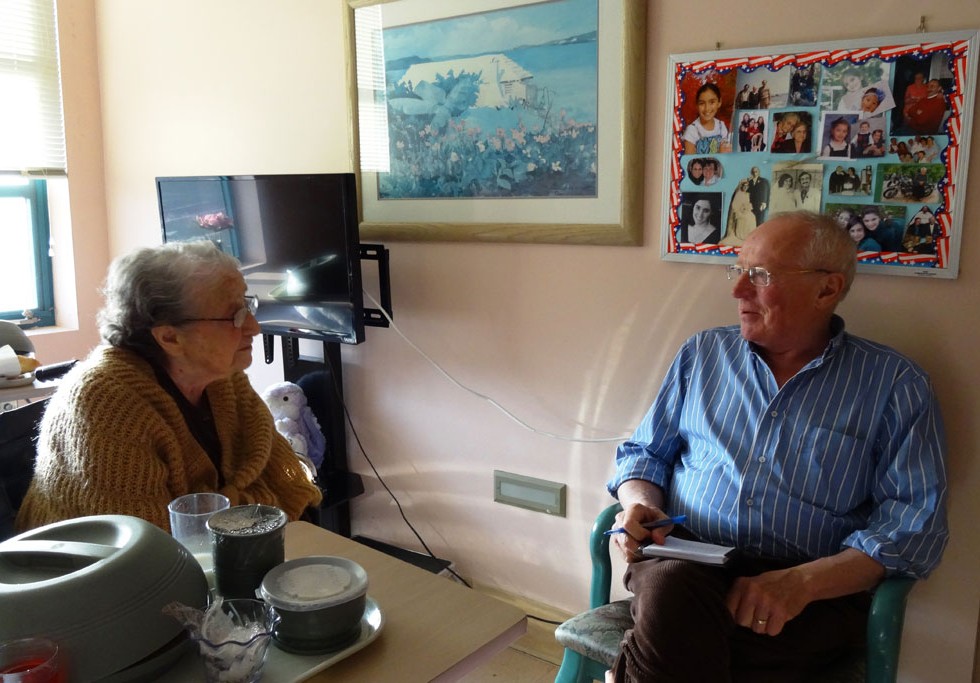 Senior resident conversing with staff member.